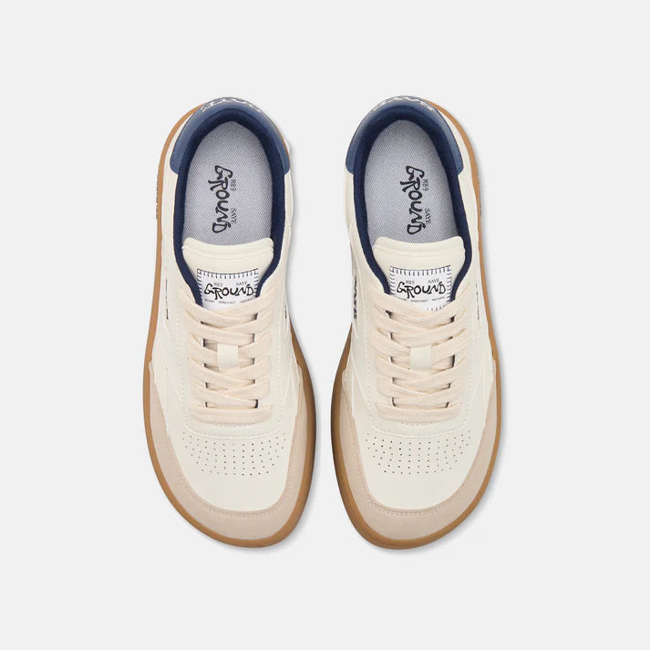 Weißer Barefoot Sneaker von Saye mit brauner Sohle und weißen Schnürsenkeln, an der Ferse mit blauen Akzenten, seitlich Markenname Saye in blau, Ansicht von oben