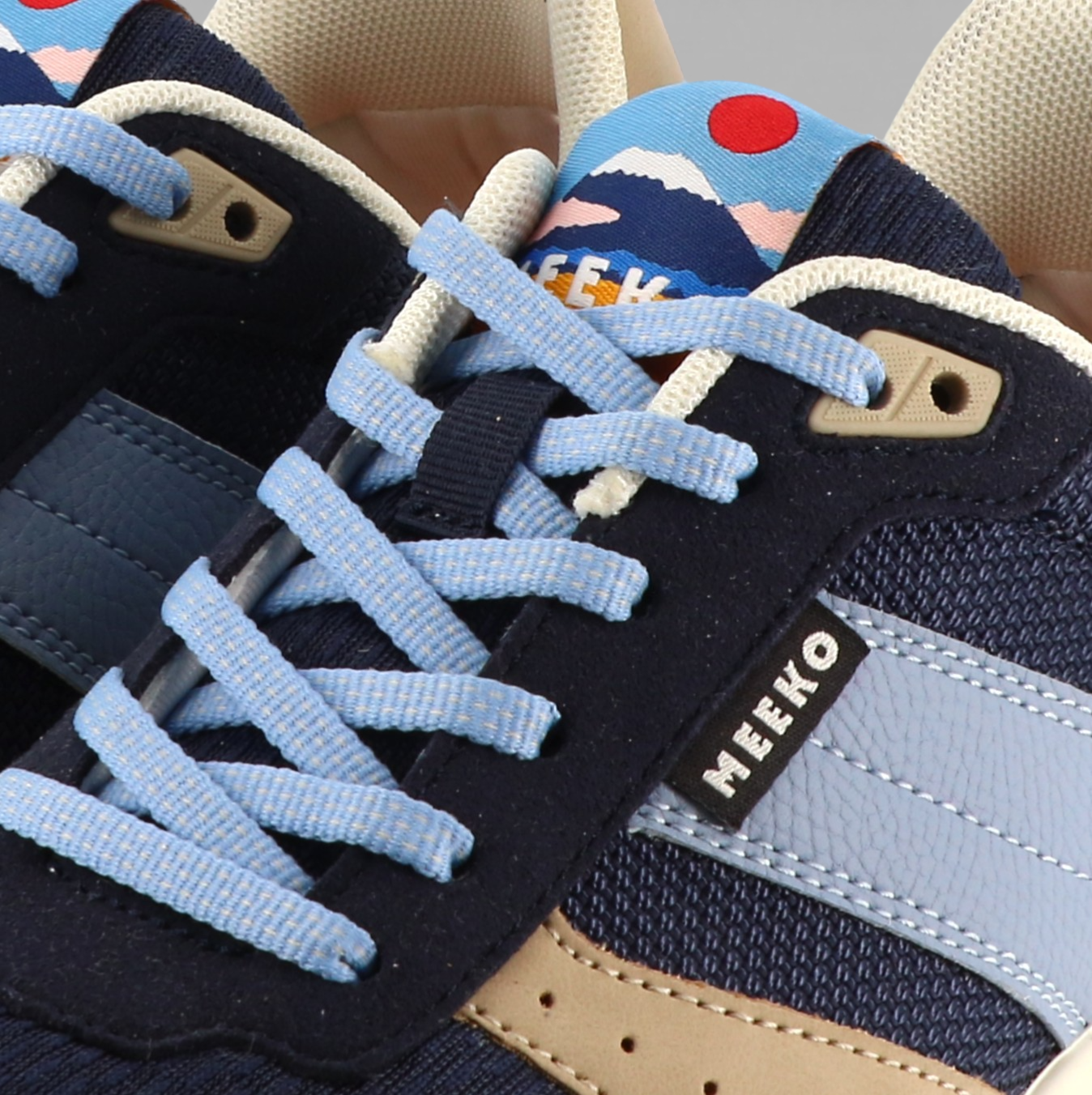 Blauer Sneaker von Meeko mit hellblauem und sandfarbenem Streifen an der Seite, Detailansicht mit blauen Schnürsenkeln