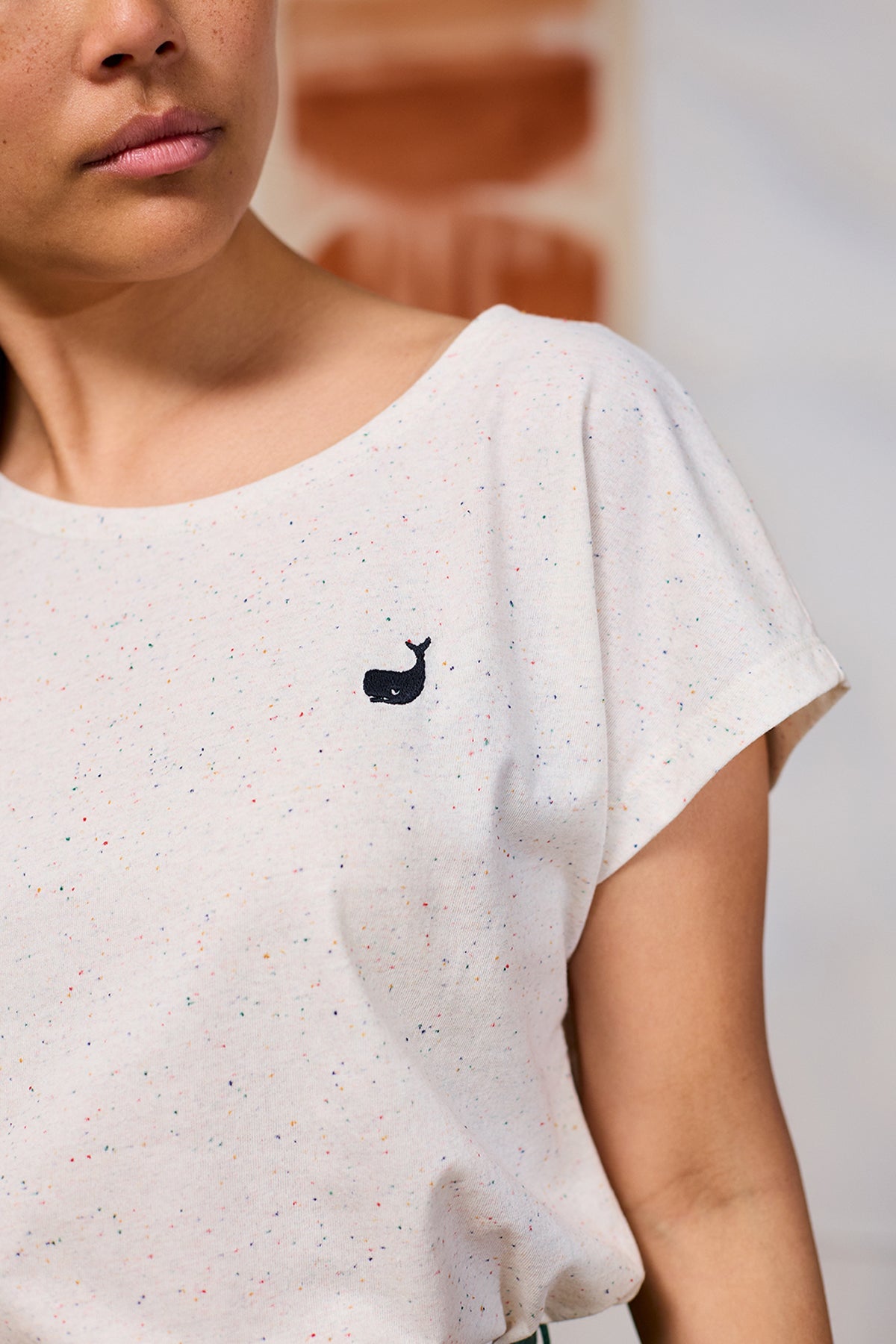 T-shirt sans manches de TwoThirds avec rayures blanches et tissu à petits grains, vue détaillée sur le mannequin avec logo de la marque brodé sur la poitrine gauche avec un baleineau bleu